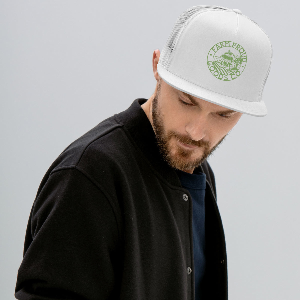 white Farm Proud Goods trucker hat with green circular farm logo featuring livestock, fields, barn, and trees on the front.